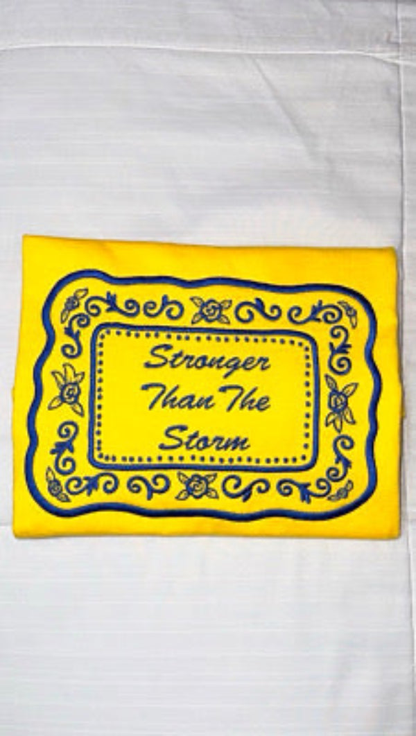 Yellow sweater with blue border and text 'Stronger Than The Storm' on a white background