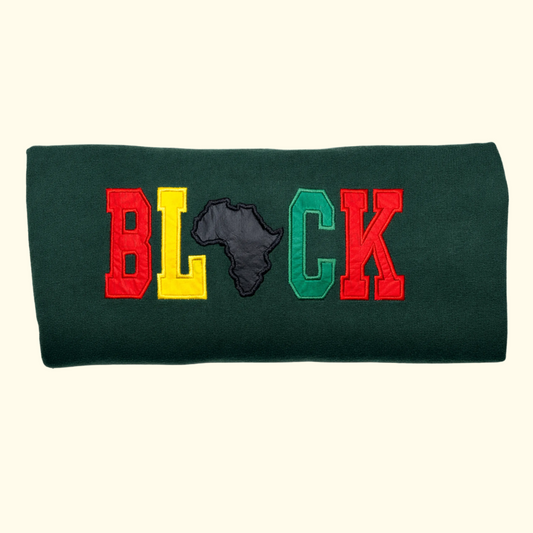 Folded BLACK embroidered sweatshirt featuring multicolor appliqué lettering on dark green fabric