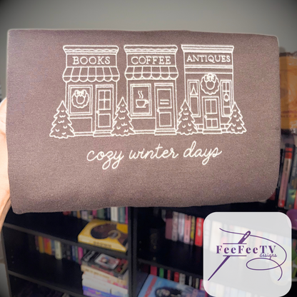 Embroidered brown sweatshirt with text ‘cozy winter days’, a bookstore, Coffee shop, Antique store. 