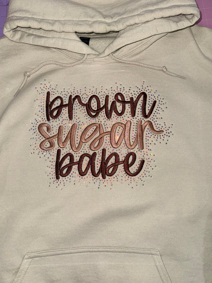 Tan-colored hoodie with decorative text design brown sugar babe with rhinestone detailing