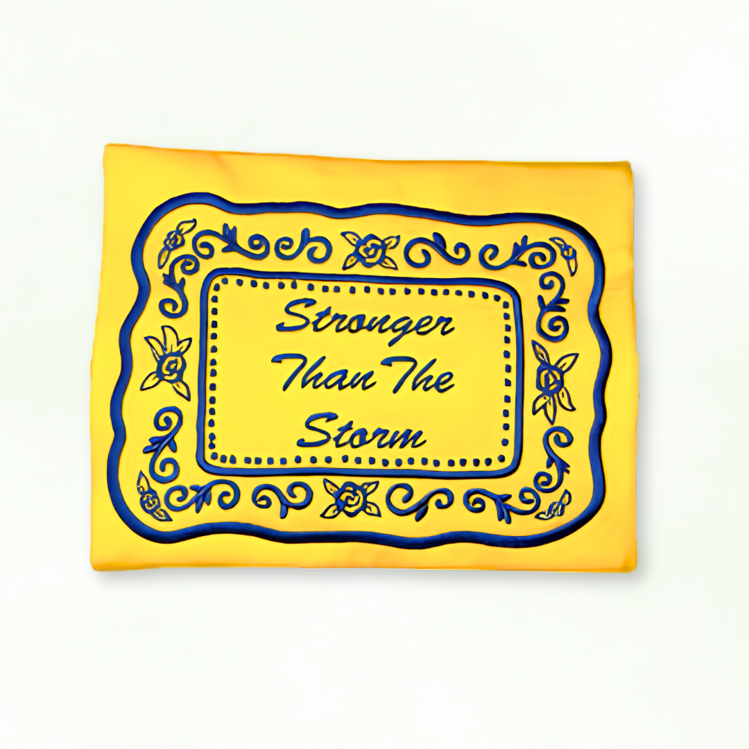 Yellow sweatshirt with blue decorative border and text 'Stronger Than The Storm' on a white background
