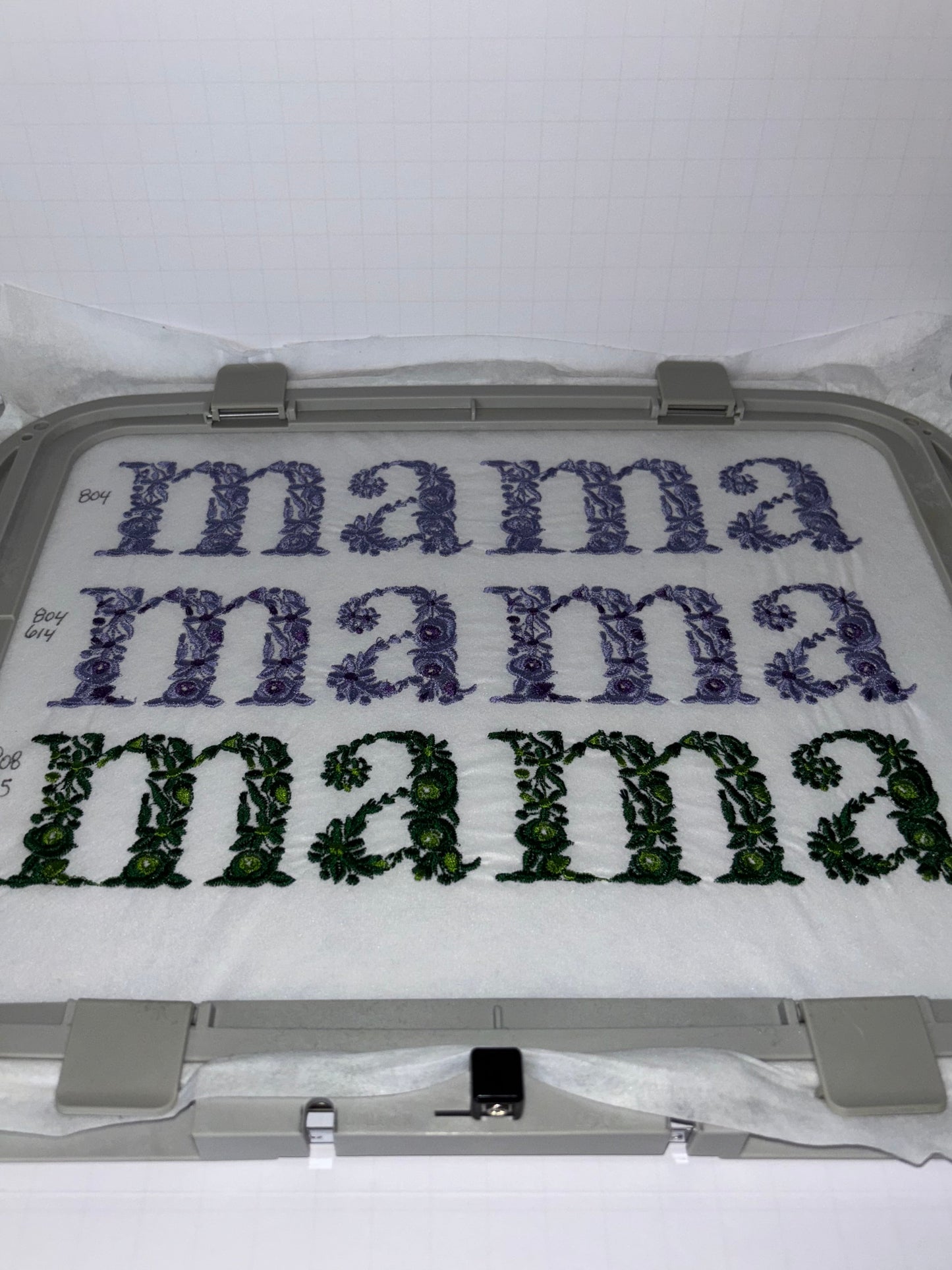 Embroidery hoop with floral mama text embroidery design on a white background