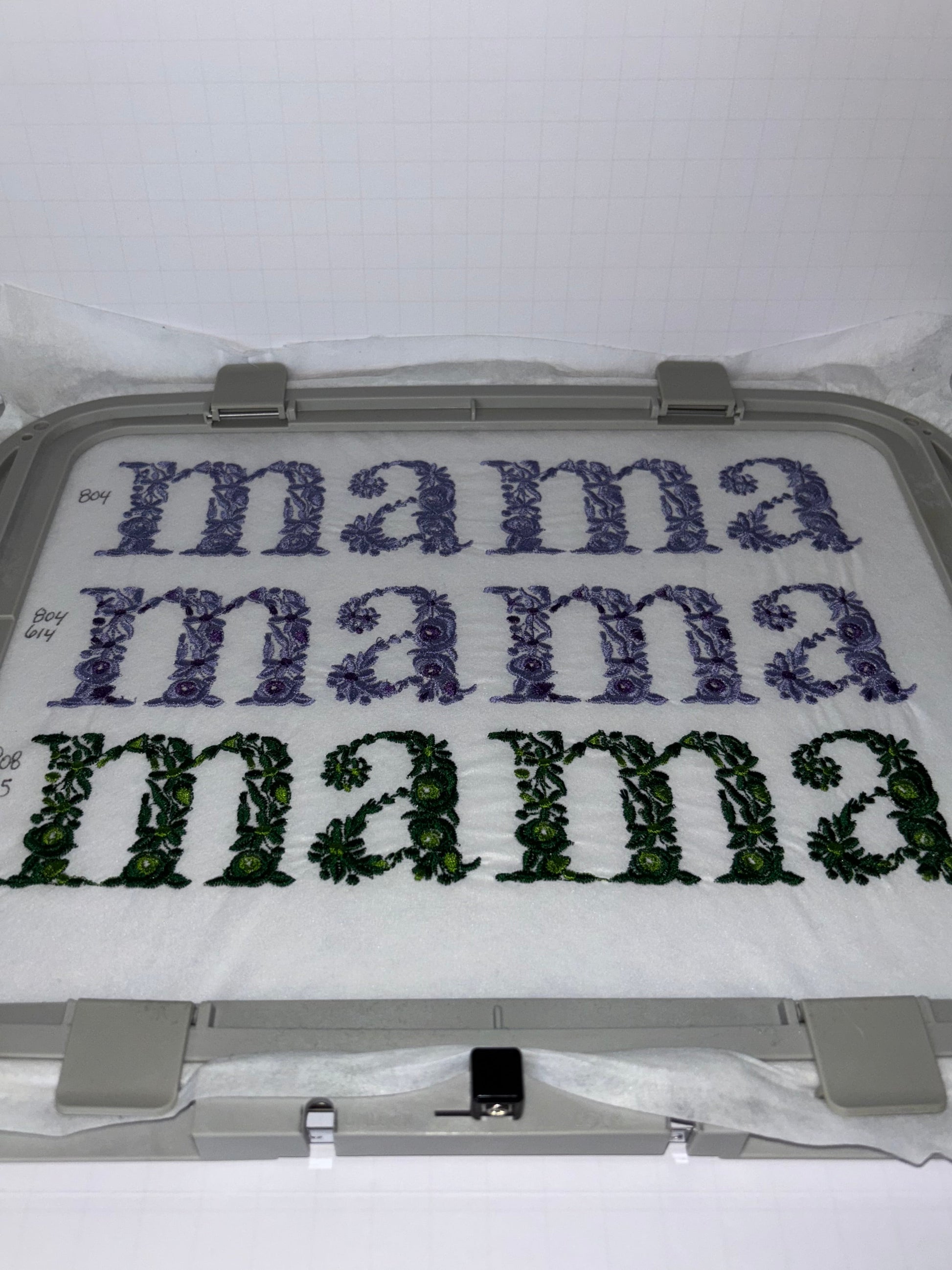 Embroidery hoop with floral mama text embroidery design on a white background