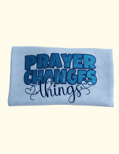 Blue sweatshirt with 'PRAYER CHANGES THINGS' text on a white background