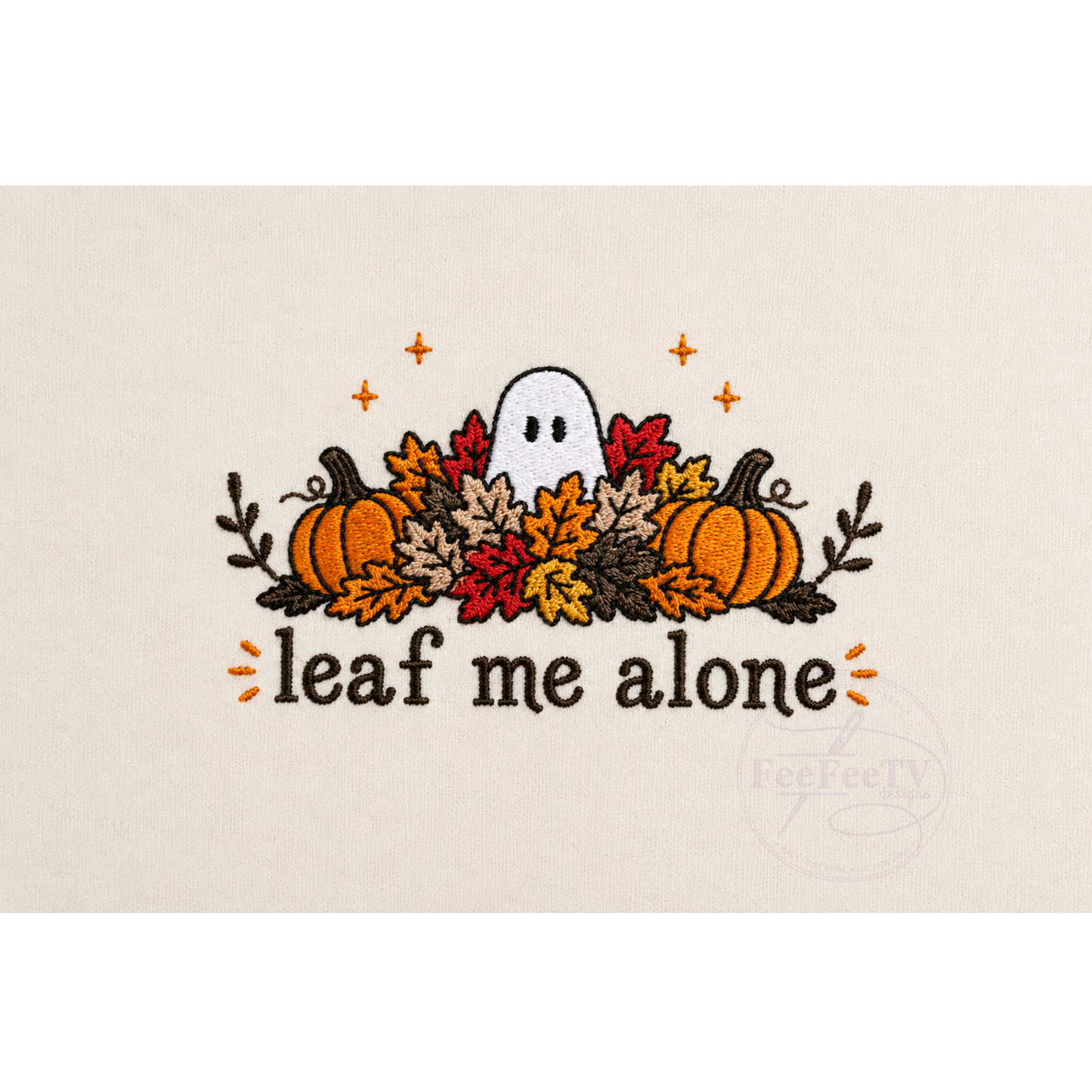 A embroidery design on a light beige fabric background, featuring a white ghost surrounded by orange, red, and yellow autumn leaves, two pumpkins, and the text 'leaf me alone'.