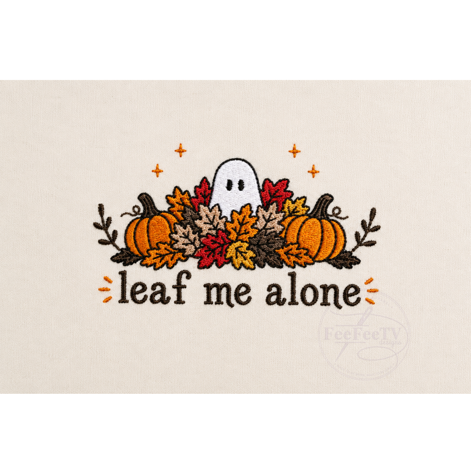 A embroidery design on a light beige fabric background, featuring a white ghost surrounded by orange, red, and yellow autumn leaves, two pumpkins, and the text 'leaf me alone'.