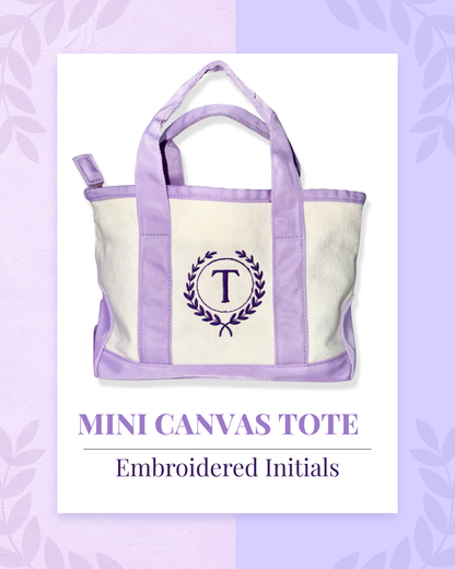 Mini canvas tote bag with embroidered initials on a purple background