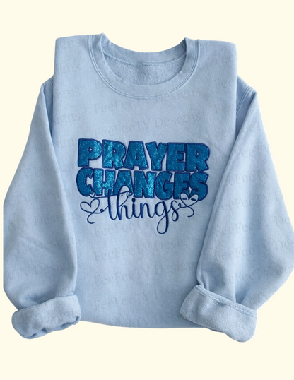 Light blue sweatshirt with 'PRAYER CHANGES THINGS' text on a white background